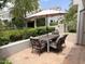 Inviting patio area features a dining table with umbrella and lush greenery, perfect for outdoor entertaining at 7272 E Gainey Ranch Rd # 122, Scottsdale, AZ 85258