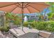 Inviting patio with umbrella-covered table, surrounded by lush greenery and overlooking a water fountain at 7272 E Gainey Ranch Rd # 122, Scottsdale, AZ 85258