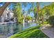 Picturesque view of the pond with a fountain, surrounded by lush trees and well-maintained green space at 7272 E Gainey Ranch Rd # 122, Scottsdale, AZ 85258