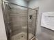 Bathroom featuring a tiled shower with glass door, showerhead, and grab bar at 7272 E Gainey Ranch Rd # 122, Scottsdale, AZ 85258