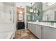 Stylish bathroom featuring dual vanities, unique tile accents, and a modern glass-enclosed shower at 7503 S Roanoke St, Gilbert, AZ 85298