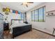 A bright bedroom featuring a large window, ceiling fan and stylish decor at 7503 S Roanoke St, Gilbert, AZ 85298