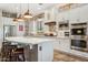 Bright kitchen features an expansive island, stainless appliances, brick accent wall and stylish pendant lighting at 7503 S Roanoke St, Gilbert, AZ 85298