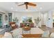 Open-concept living room with a ceiling fan, a cozy leather chair, and a modern entertainment center at 7503 S Roanoke St, Gilbert, AZ 85298