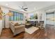 Inviting living room with hardwood floors, large windows, and a modern ceiling fan at 7503 S Roanoke St, Gilbert, AZ 85298