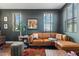 Inviting living room features a comfortable leather couch, natural light, and hardwood floors at 7503 S Roanoke St, Gilbert, AZ 85298