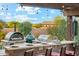 Entertain in this outdoor kitchen with pizza oven, stainless steel grill, and bar seating under a decorative pergola at 7503 S Roanoke St, Gilbert, AZ 85298