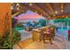 Covered patio features a bar, grill, and seating area with a peaceful backyard setting and a view of the pool at 7503 S Roanoke St, Gilbert, AZ 85298
