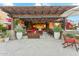 Covered outdoor patio with fireplace, ample seating, dining table and lush landscaping for luxurious outdoor living at 7503 S Roanoke St, Gilbert, AZ 85298