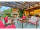 Cozy outdoor patio with a fireplace, comfortable seating, and lush greenery at 7503 S Roanoke St, Gilbert, AZ 85298