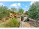 Beautiful backyard pool with lounge chairs, a shade umbrella, stone water feature, and mature landscaping for privacy at 7503 S Roanoke St, Gilbert, AZ 85298