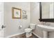 Cozy powder room with a pedestal sink, decorative mirror, and tasteful artwork adding a touch of charm at 7503 S Roanoke St, Gilbert, AZ 85298