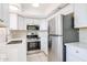 The kitchen features stainless steel appliances, white cabinetry, and modern countertops at 8023 N 49Th Ave, Glendale, AZ 85302