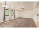 Bright living room features wood floors, modern ceiling fan, neutral paint, and a window with grey curtains at 8155 E Roosevelt St # 205, Scottsdale, AZ 85257