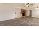 Spacious living room featuring wood floors, modern ceiling fan, neutral paint, adjacent kitchen, and closet space at 8155 E Roosevelt St # 205, Scottsdale, AZ 85257