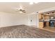 Open living room features wood floors, modern ceiling fan, neutral paint, adjacent kitchen and front door at 8155 E Roosevelt St # 205, Scottsdale, AZ 85257