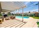 Expansive backyard featuring a pool, covered patio, comfortable seating area, and a decorative cactus mural at 8315 E Devonshire Ave, Scottsdale, AZ 85251