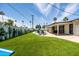 Expansive backyard with a sparkling pool, artificial turf, a patio, an umbrella, cactus art and lounge chairs at 8315 E Devonshire Ave, Scottsdale, AZ 85251