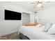 Bedroom features soft, natural light, a ceiling fan, and mounted TV for entertainment at 8315 E Devonshire Ave, Scottsdale, AZ 85251