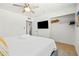 Bright bedroom with a ceiling fan, large TV, and a well-organized closet for ample storage at 8315 E Devonshire Ave, Scottsdale, AZ 85251