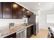 Updated kitchen with granite counters, dark wood cabinets, and stainless steel appliances at 8315 E Devonshire Ave, Scottsdale, AZ 85251
