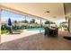 Covered patio with dining and lounge areas overlooking a sparkling pool and artful cacti mural at 8315 E Devonshire Ave, Scottsdale, AZ 85251