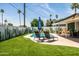 Inviting backyard pool area with lounge chairs, cactus-themed privacy fence, and manicured artificial grass at 8315 E Devonshire Ave, Scottsdale, AZ 85251