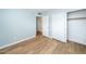 A simple bedroom featuring wood-look flooring, neutral walls, and a sliding door closet at 909 W San Mateo Ct, Gilbert, AZ 85233