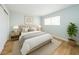 Bright staged bedroom featuring wood-look flooring, neutral walls, stylish furniture, and a large window at 909 W San Mateo Ct, Gilbert, AZ 85233