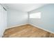 A bright bedroom features wood-look flooring, a white door, and a window with blinds at 909 W San Mateo Ct, Gilbert, AZ 85233