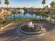 Tranquil lakefront view with fountain, lined with palm trees, luxury homes, and lush green spaces at 909 W San Mateo Ct, Gilbert, AZ 85233