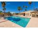 Sparkling community pool with lounge chairs and a patio area amidst a sunny, tropical atmosphere at 909 W San Mateo Ct, Gilbert, AZ 85233