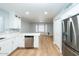 Bright kitchen features white cabinets, stainless steel appliances, and a stylish backsplash, leading into living space at 909 W San Mateo Ct, Gilbert, AZ 85233