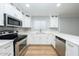 Modern kitchen with white cabinetry, stainless steel appliances, and sleek countertops, offering ample cooking space at 909 W San Mateo Ct, Gilbert, AZ 85233