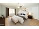 Spacious main bedroom with ceiling fan, neutral walls, wood-look floors, and stylish furniture at 909 W San Mateo Ct, Gilbert, AZ 85233