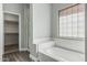 Clean bathroom with soaking tub, separate shower, and a walk-in closet at 9224 W Raymond St, Tolleson, AZ 85353
