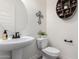 Stylish powder room with a pedestal sink, a round mirror, and decorative wall art at 9448 W Villa Hermosa --, Peoria, AZ 85383