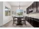 Bright dining area features wood-look tile flooring, dark wood cabinets, and a window bringing in natural light at 9448 W Villa Hermosa --, Peoria, AZ 85383
