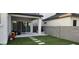 View of a covered back patio with stone flooring, artificial turf, and neutral paint at 10351 W Deanna Dr, Peoria, AZ 85382