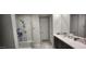 Bright bathroom features a glass enclosed shower, double vanity with marble counters, and tile floors at 10351 W Deanna Dr, Peoria, AZ 85382