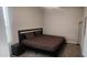 Bedroom with a black bed frame, patterned bedding, carpet, and minimalist décor at 10351 W Deanna Dr, Peoria, AZ 85382