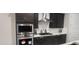 Close-up of a contemporary kitchen featuring stainless steel appliances, dark cabinetry, and a white backsplash at 10351 W Deanna Dr, Peoria, AZ 85382