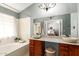 Bright bathroom boasts double stone vessel sinks, stylish vanity, soaking tub, and a neutral color palette at 1214 W Sand Dune Dr, Gilbert, AZ 85233