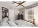 Cozy bedroom with soft bedding, ceiling fan, and ample natural light from the large window at 1214 W Sand Dune Dr, Gilbert, AZ 85233