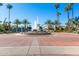 Picturesque community entrance featuring palm trees and a water fountain at 1214 W Sand Dune Dr, Gilbert, AZ 85233