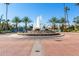 Fountain in community entrance surrounded by palm trees and residential landscaping at 1214 W Sand Dune Dr, Gilbert, AZ 85233