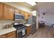 Modern kitchen featuring stainless steel appliances, wooden cabinets, and a seamless connection to dining area at 1219 E Avenida Isabela --, Casa Grande, AZ 85122
