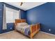 Cozy bedroom features blue walls, ceiling fan, natural light, and plush carpet at 1405 S Honeysuckle Cir, Gilbert, AZ 85296
