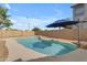 Backyard pool with rock feature and relaxing umbrella at 1405 S Honeysuckle Cir, Gilbert, AZ 85296