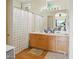 Bright bathroom featuring wood floors, a double sink vanity, and a shower with patterned curtains at 14626 N 132Nd Ave, Surprise, AZ 85379